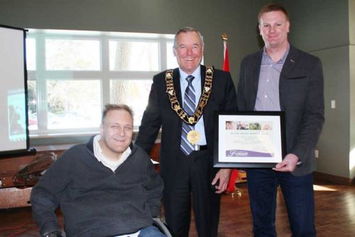 Left to right: Neil Allan - chair of the Frontenac County Accessibility Commitee, and Warden Dennis Doyle presented the 2014 Accessibility Award to Joe Ryan and the absent Brendan Hicks of Accessible Living - Kingston